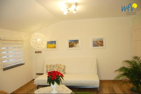 un soggiorno con divano bianco e tavolo di Ferienhaus Rademacher Ferienwohnung 2 a Binz