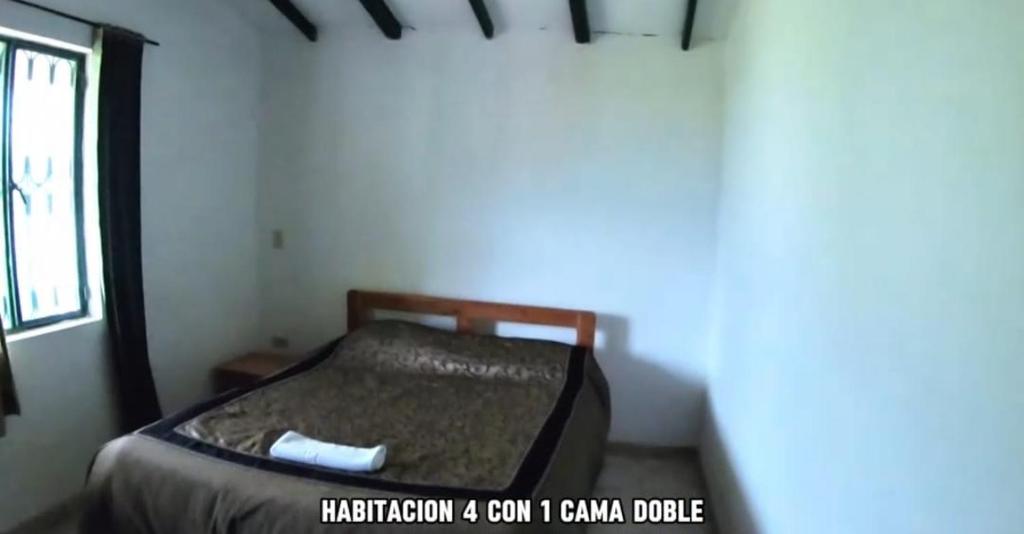 uma pequena cama num quarto com uma janela em Finca Hotel em Sutamarchán