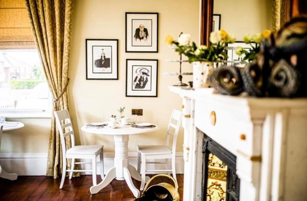 a dining room with a table and a fireplace at Abbotsleigh of Whitby in Whitby