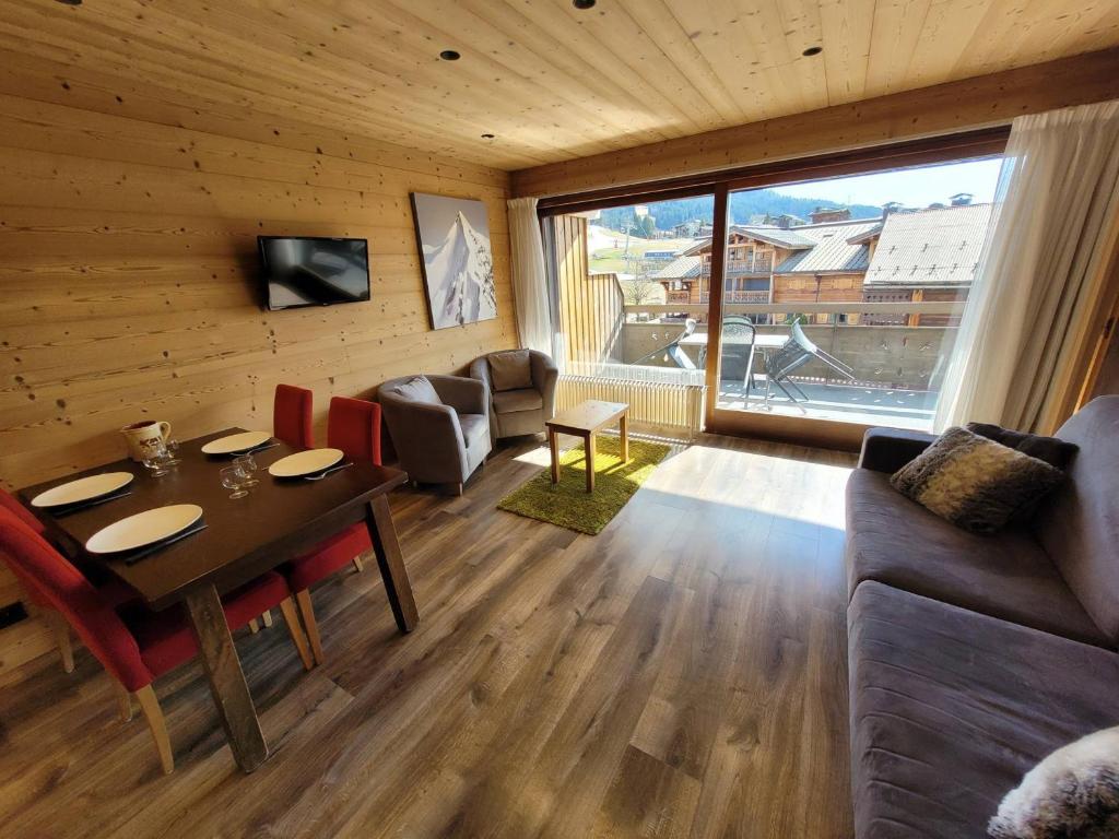 a living room with a table and a couch at Appartement rénové 3* au pied des pistes, balcon, parking, WiFi, pour 4 personnes - FR-1-598-133 in Les Gets