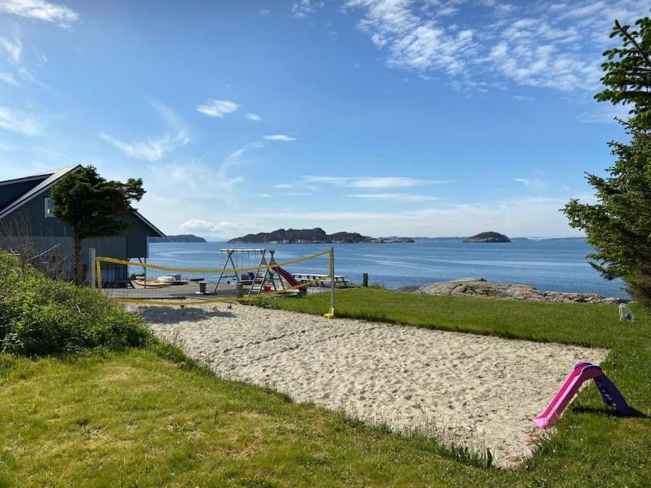 una playa de arena con un parque infantil junto al agua en House by sea - Bergen, Norway. Free boat., en Askøy