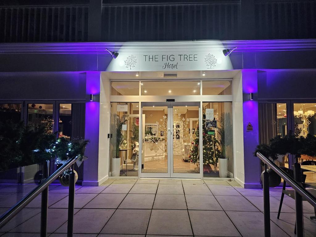 una tienda frente a la noche con luces púrpuras en The Fig Tree Hotel en Shanklin