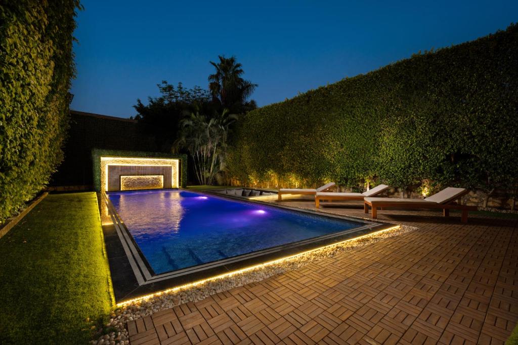 a swimming pool with lights in a backyard at night at Zyra villa with pool and waterfall in New Cairo in Cairo