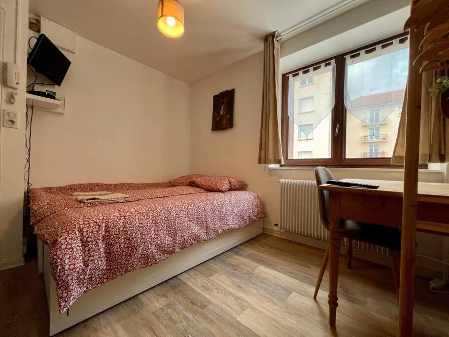 um quarto com uma cama, uma secretária e uma janela em Appartement 2 prsn / Proche Centre-Ville em Besançon