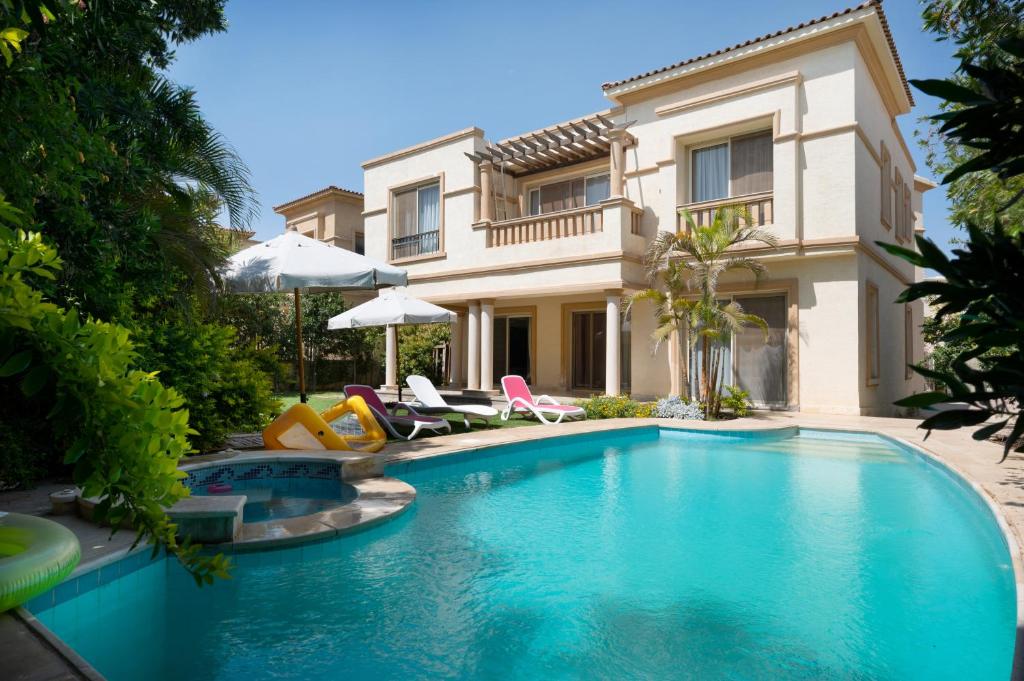 a swimming pool in front of a villa at Zyra Luxury villa with pool and Jacuzzi in New Cairo in Cairo