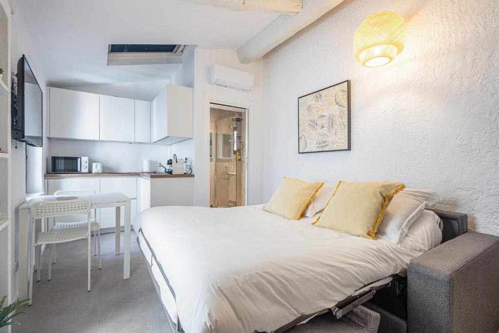 une petite chambre avec un lit et une cuisine dans l'établissement Joli studio Cannes marché forville, à Cannes