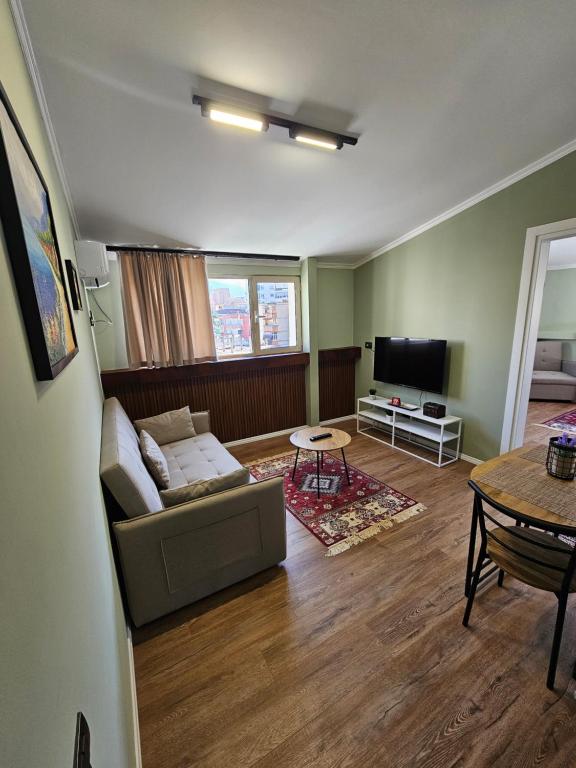 un soggiorno con divano e tavolo di Vila TAFA Apartments a Tirana