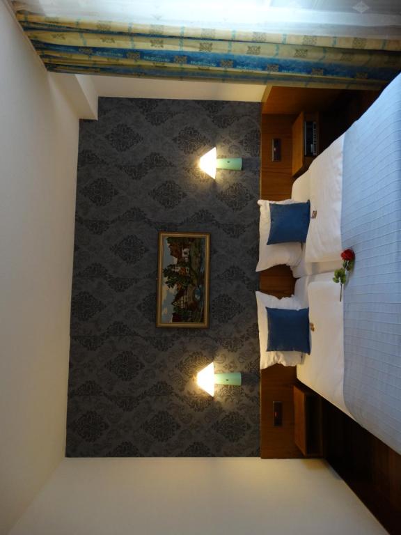 ein Schlafzimmer mit blauen Kissen und einer Wand in der Unterkunft S&L Hotel Neuss in Neuss