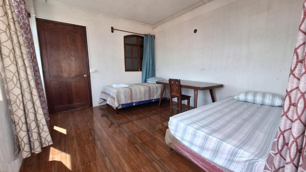 a bedroom with a bed and a desk and a table at Casa Yelitza in San Pedro La Laguna