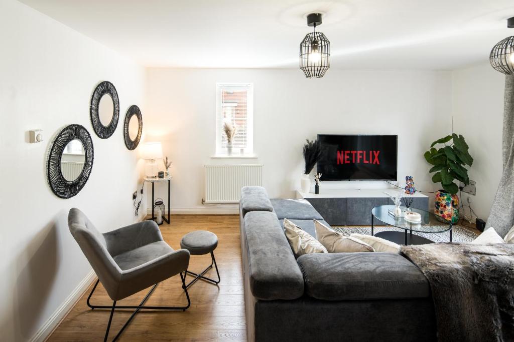 a living room with a gray couch and chairs at Bucks Luxury Apartment - free parking in Buckinghamshire