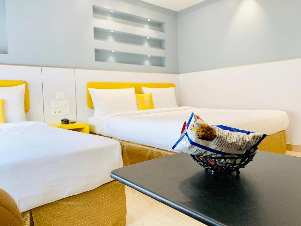 una camera d'albergo con due letti e un tavolo di International Embassy Suites a Nuova Delhi