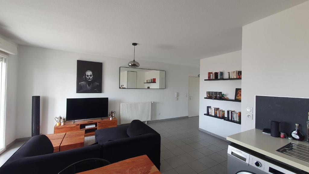 sala de estar con sofá y TV en Appartement 3 pièces + terrasse en Marsella