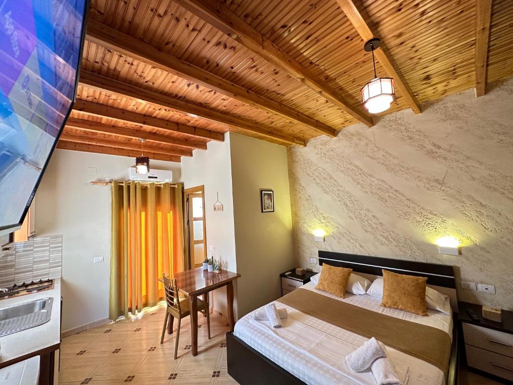 a bedroom with two beds and a table in a room at Vila Arial in Vlorë