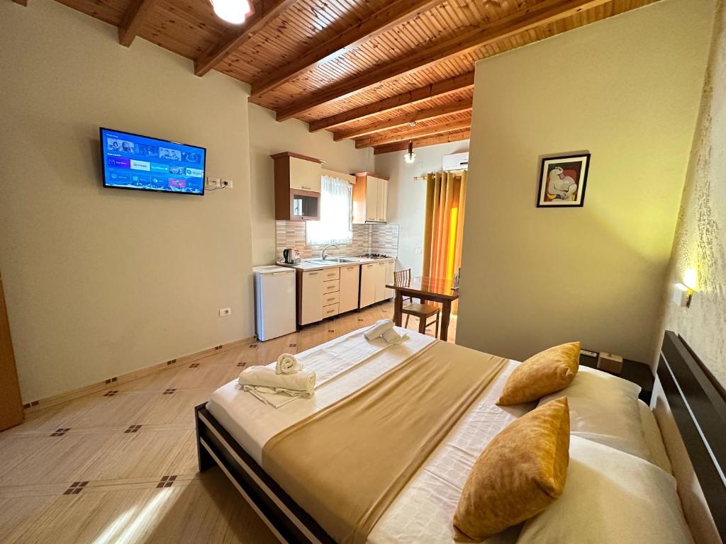 a bedroom with a large bed with a television on the wall at Vila Arial in Vlorë