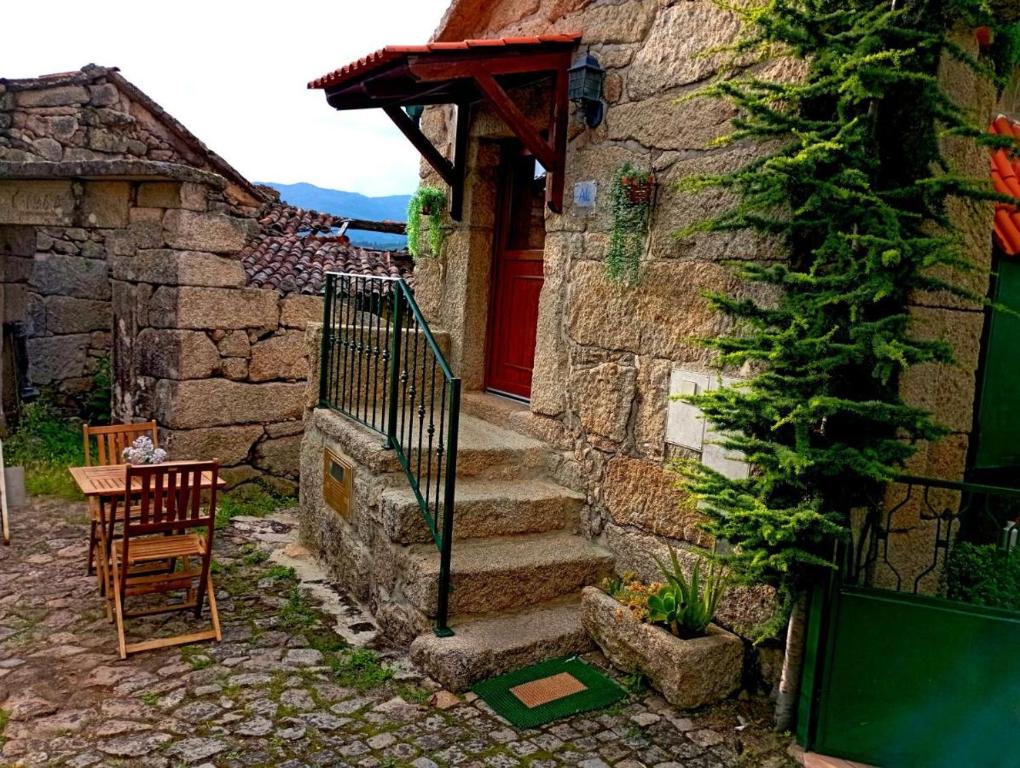 kamienny dom z czerwonymi drzwiami i schodami w obiekcie Casa Do Charco - Peneda Gerês w mieście Geres