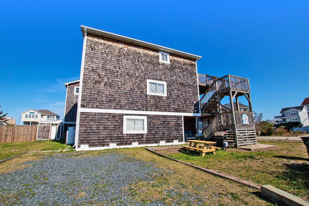 a brick house with a staircase on the side of it at NH301, Driftwood Dreaming- Hot Tub, Oceanside, Close to Ocean! in Nags Head