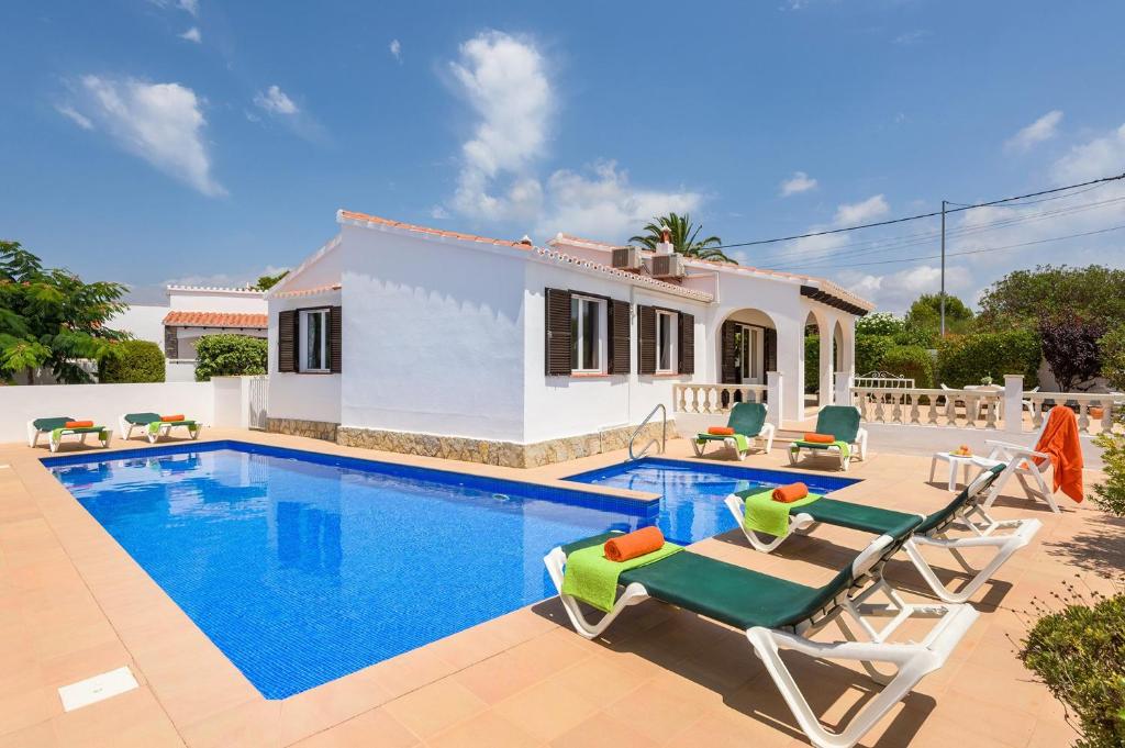 a villa with a swimming pool and a house at Villa CLAUDIA Menorca in Cala'n Porter