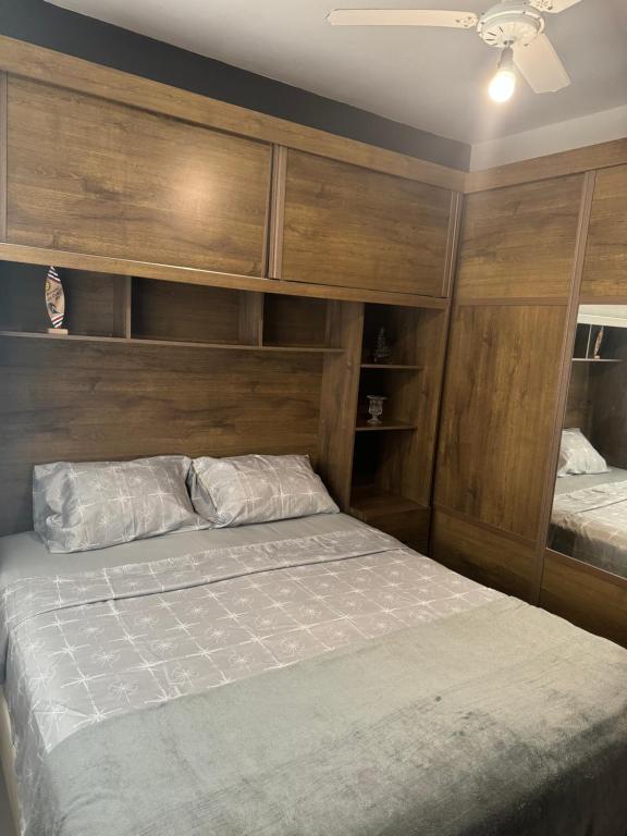 Schlafzimmer mit einem Bett und Holzwänden in der Unterkunft Serra Mar Suítes,Lofts, e casas à 300 metros das praias in Arraial do Cabo