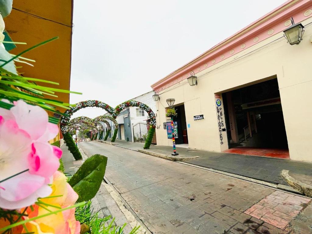an empty street with a row of archways and flowers at HOTEL EDELMIRA in Comitán de Domínguez