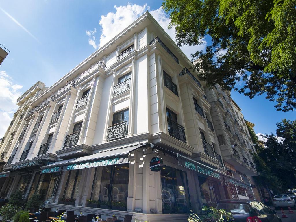 un grand bâtiment blanc au coin d'une rue dans l'établissement Antusa Palace Hotel & Spa, à Istanbul