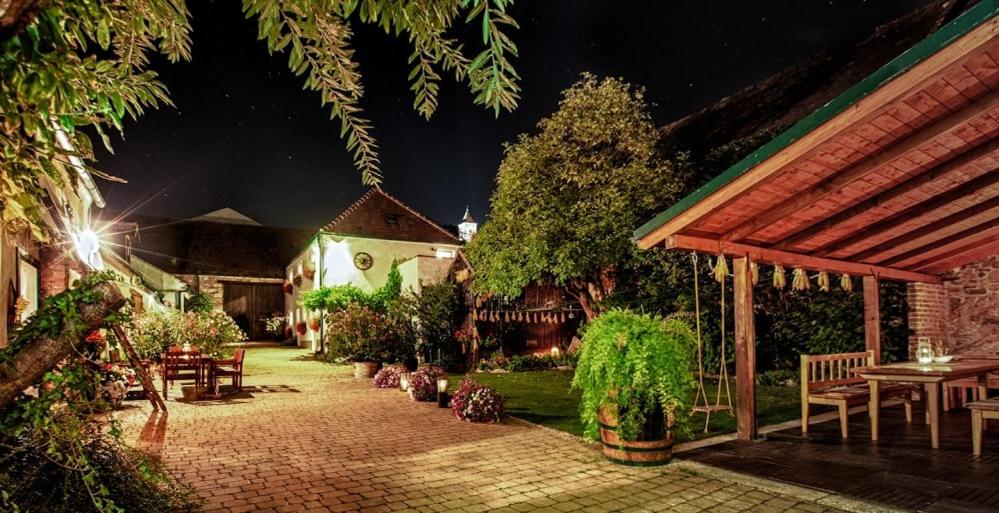 a garden at night with tables and chairs and a building at Winzerhof Agerlhof in Jois