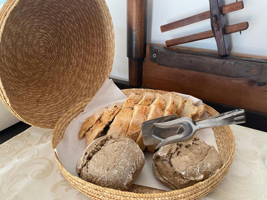 a basket with bread and a pair of tongs on a table at Vinha da Quinta in Sintra