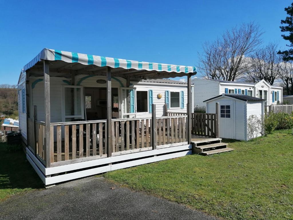 une maison avec une terrasse couverte et un kiosque dans l'établissement MOBIL HOME 4 personnes en bord de mer - Camping les Goélands, à Saint-Martin-Plage