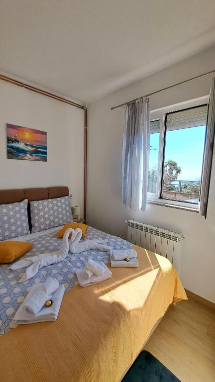 a bedroom with a bed with towels on it at Apartman Leon in Rijeka