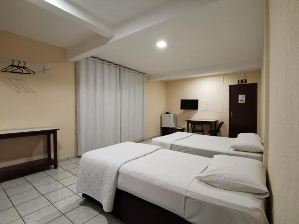 a hotel room with two beds and a television at Smart Cataratas Hotel in Foz do Iguaçu