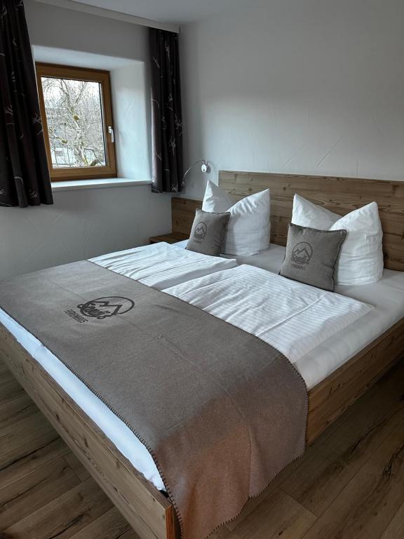 een groot bed met witte lakens en kussens in een slaapkamer bij Sandi`s Ferienhaus in Reutte