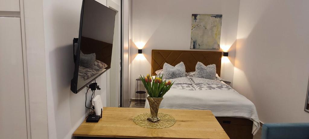 een slaapkamer met een bed met een vaas met bloemen op een tafel bij Cozy Studio Apartment LEPRIN in Labin Old Town in Labin