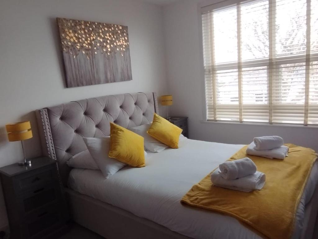een slaapkamer met een groot bed met gele kussens bij Beautiful Home in the centre of Newquay! in Newquay