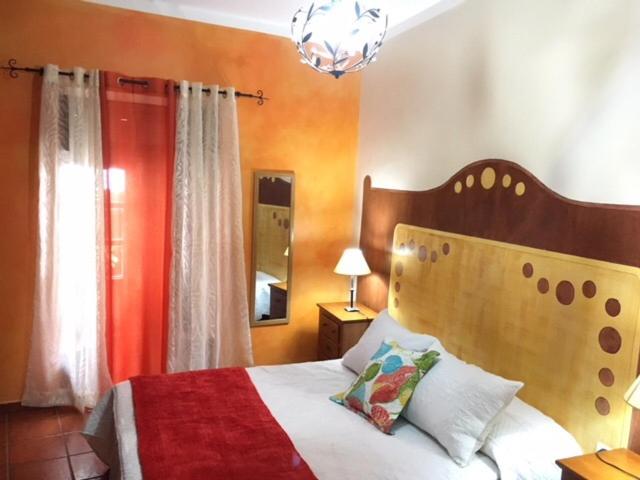 a bedroom with a bed and a chandelier at Casa Rural El Patio Agulo in Agulo