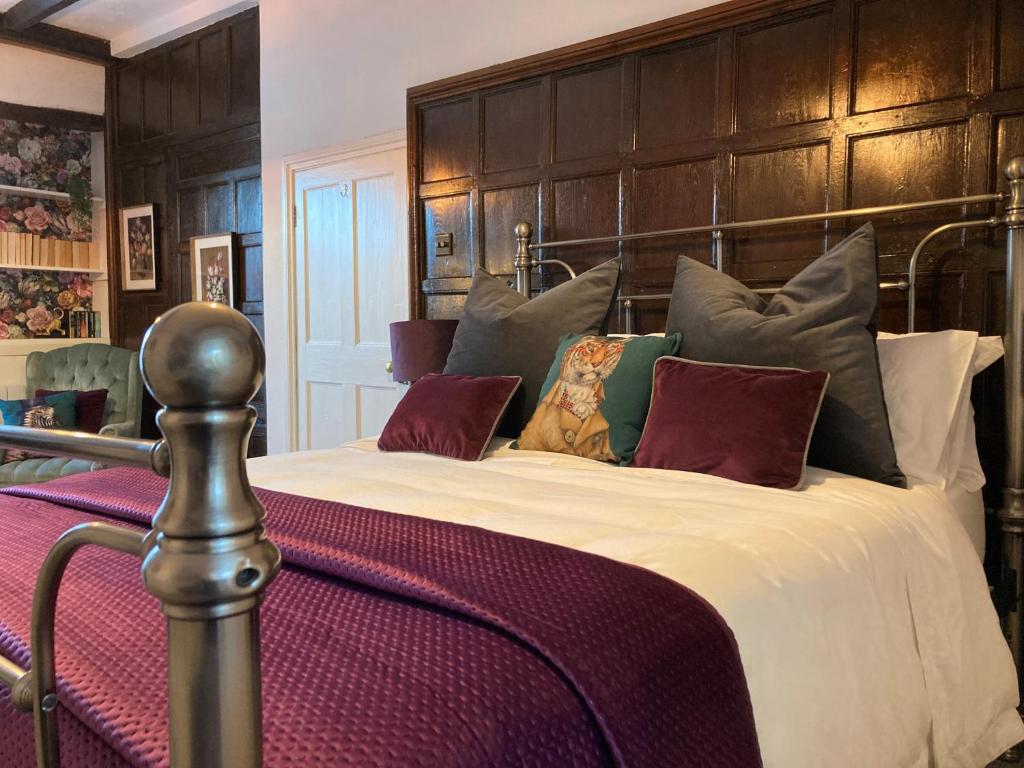 a bedroom with a large bed with a large headboard at Cromwell Cottage in Fakenham