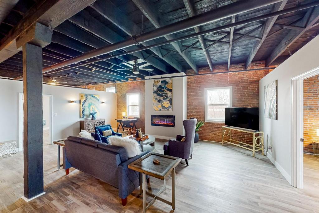 a living room with a couch and a tv at Broadway Loft in Saint Louis