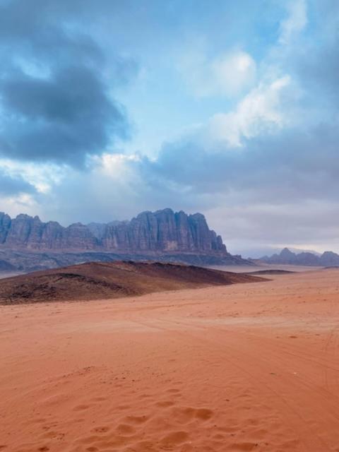 Un desierto con montañas en el fondo y un cielo azul en وادي رم, en Áqaba