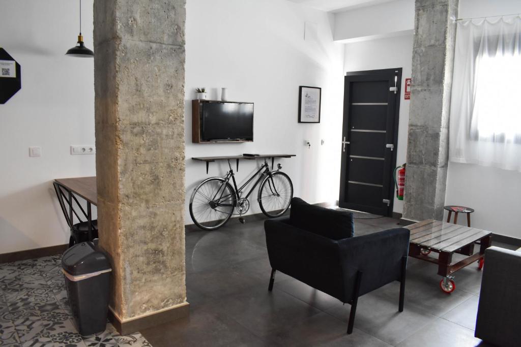 sala de estar con bicicleta, mesa y TV en Sevilla Industrial Flat en Sevilla