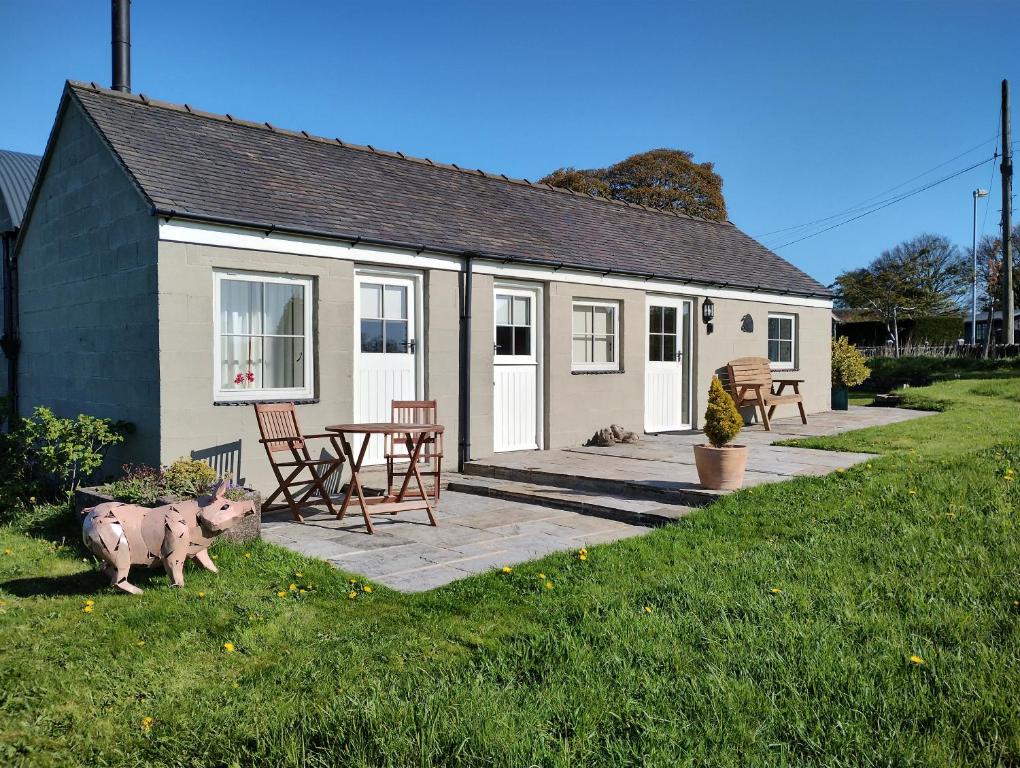 une petite maison avec une table et des chaises devant elle dans l'établissement The Pigsty, à Ashbourne