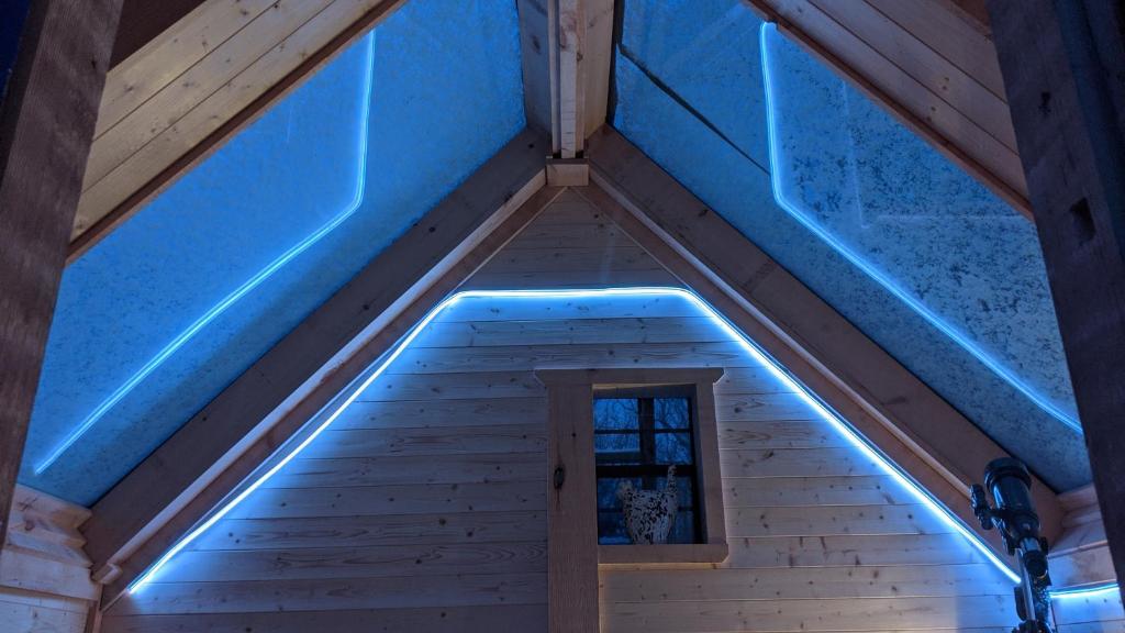 Habitación con luces azules en el techo en Stargazer tiny house en Palenville