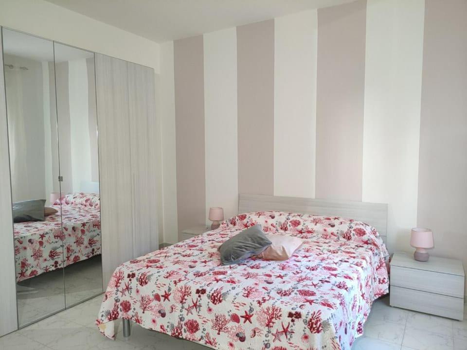 una camera con un letto con una coperta rossa e bianca di MagicaHome ad Alghero