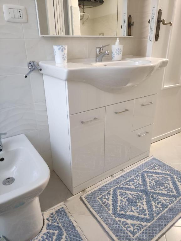un bagno bianco con lavandino e WC di MagicaHome ad Alghero
