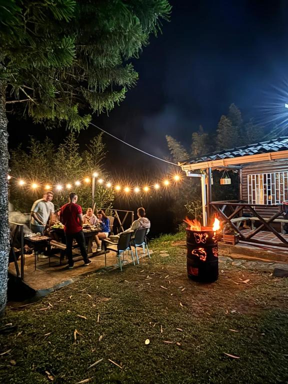 un grupo de personas sentadas en una mesa por la noche en Cabaña rústica la Pradera en Guatapé