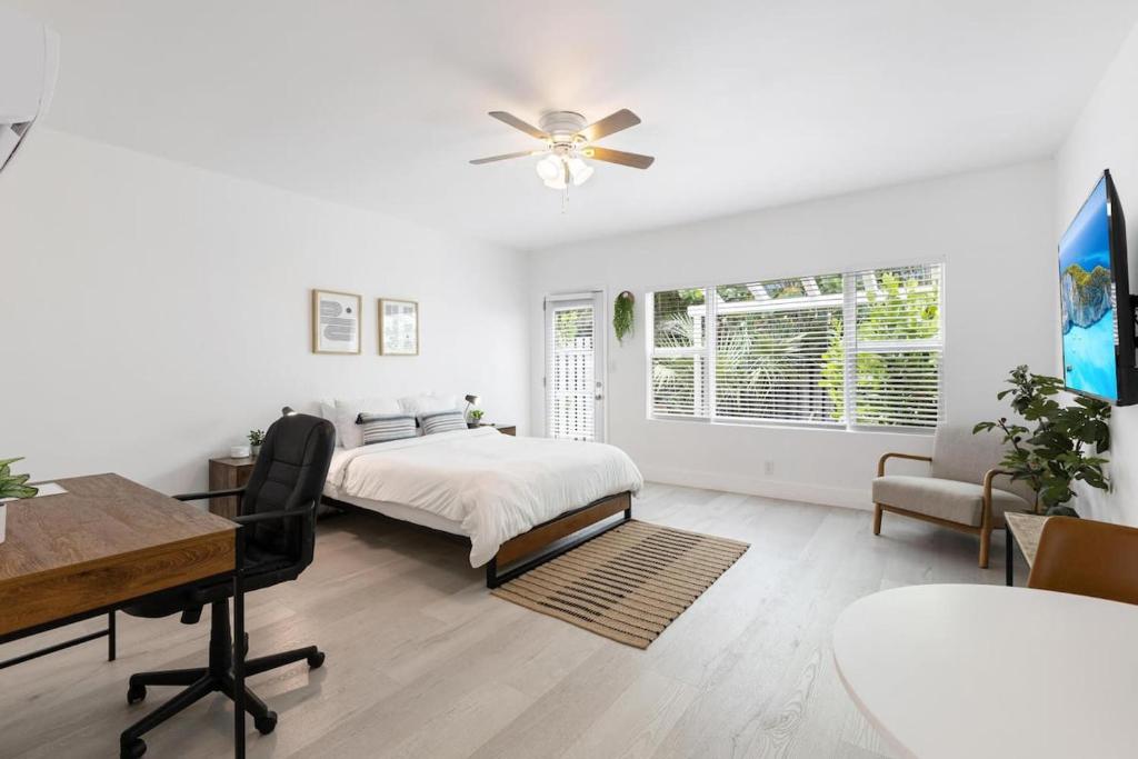 a white bedroom with a bed and a desk at Victoria Park Unique Studio close to Las Olas Blvd in Fort Lauderdale