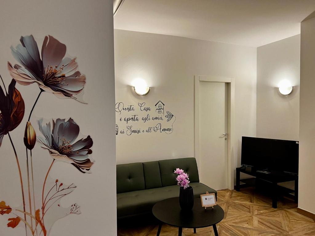 - un salon avec un canapé et des fleurs sur le mur dans l'établissement EmilBo' House, à San Lazzaro di Savena