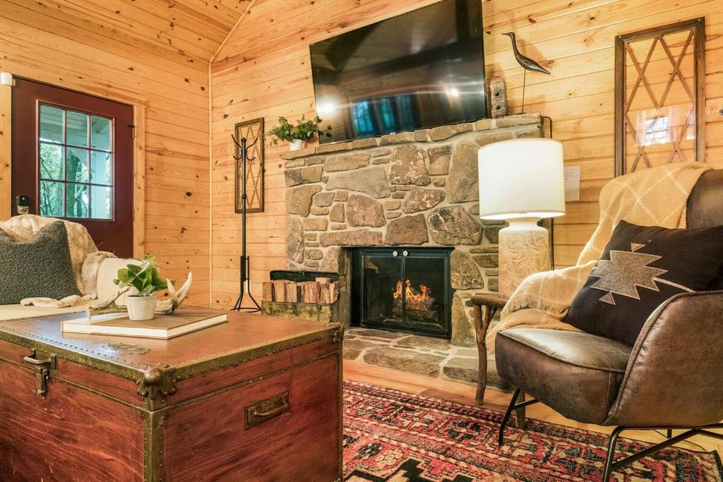 - un salon avec une cheminée en pierre dans une cabine dans l'établissement Pattersons Cabin-Nature Retreat-10 Mi to DT, à Garfield