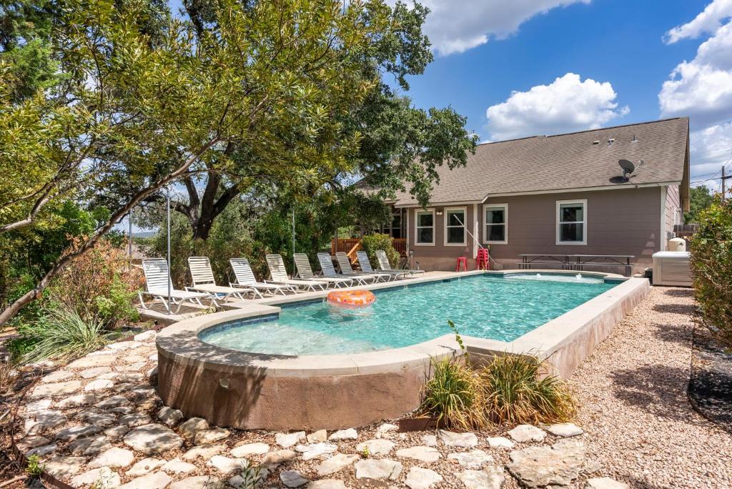 een zwembad met stoelen en een huis bij Luxury Lake Travis Estate with a Stunning Pool and Spectacular Outdoor Space in Austin