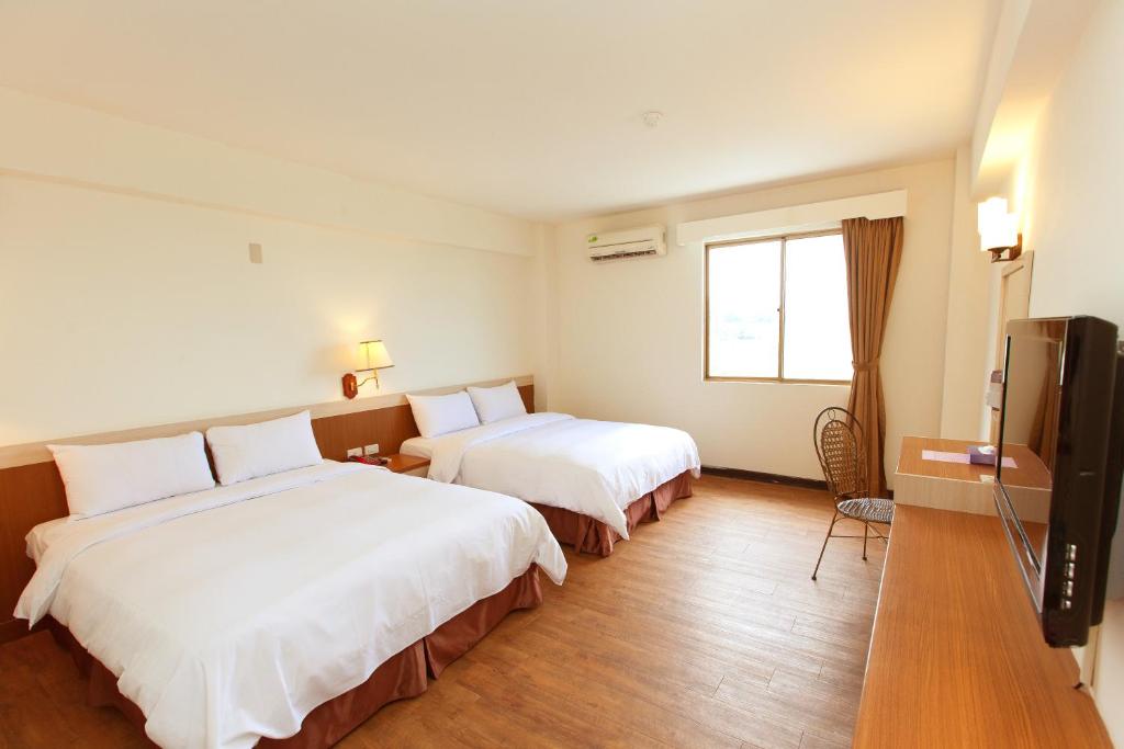 a hotel room with two beds and a flat screen tv at Yawan Hotel in Wenquan