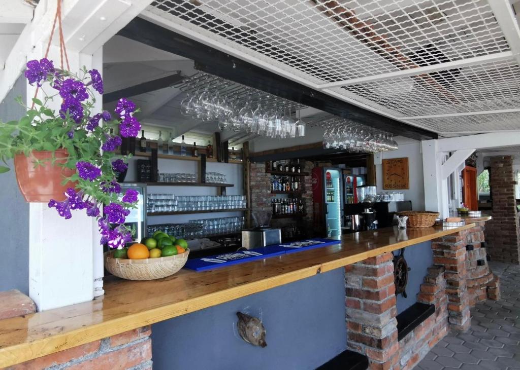 a bar with flowers on the counter of a restaurant at Anamaria in Kaštela