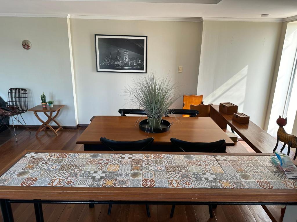una sala de estar con mesa de comedor con una planta en Impecable apartamento a 5 minutos de la terminal, en Artigas