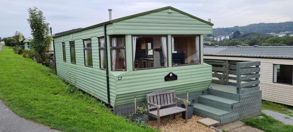 ein kleines grünes Haus am Straßenrand in der Unterkunft Spacious 2 bedroomed mobile home in Aberystwyth
